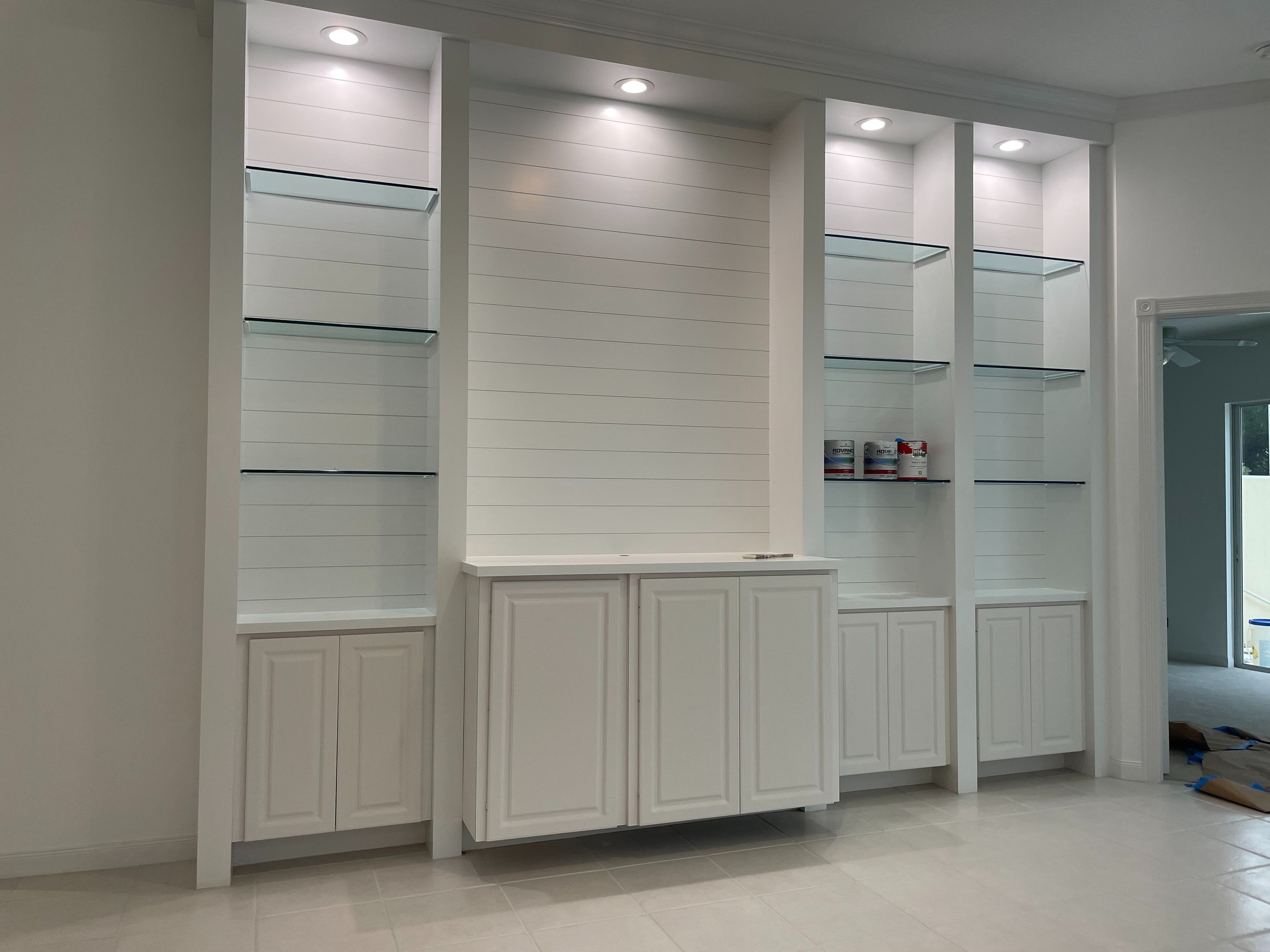 White built-in shelving and cabinets with shiplap finish