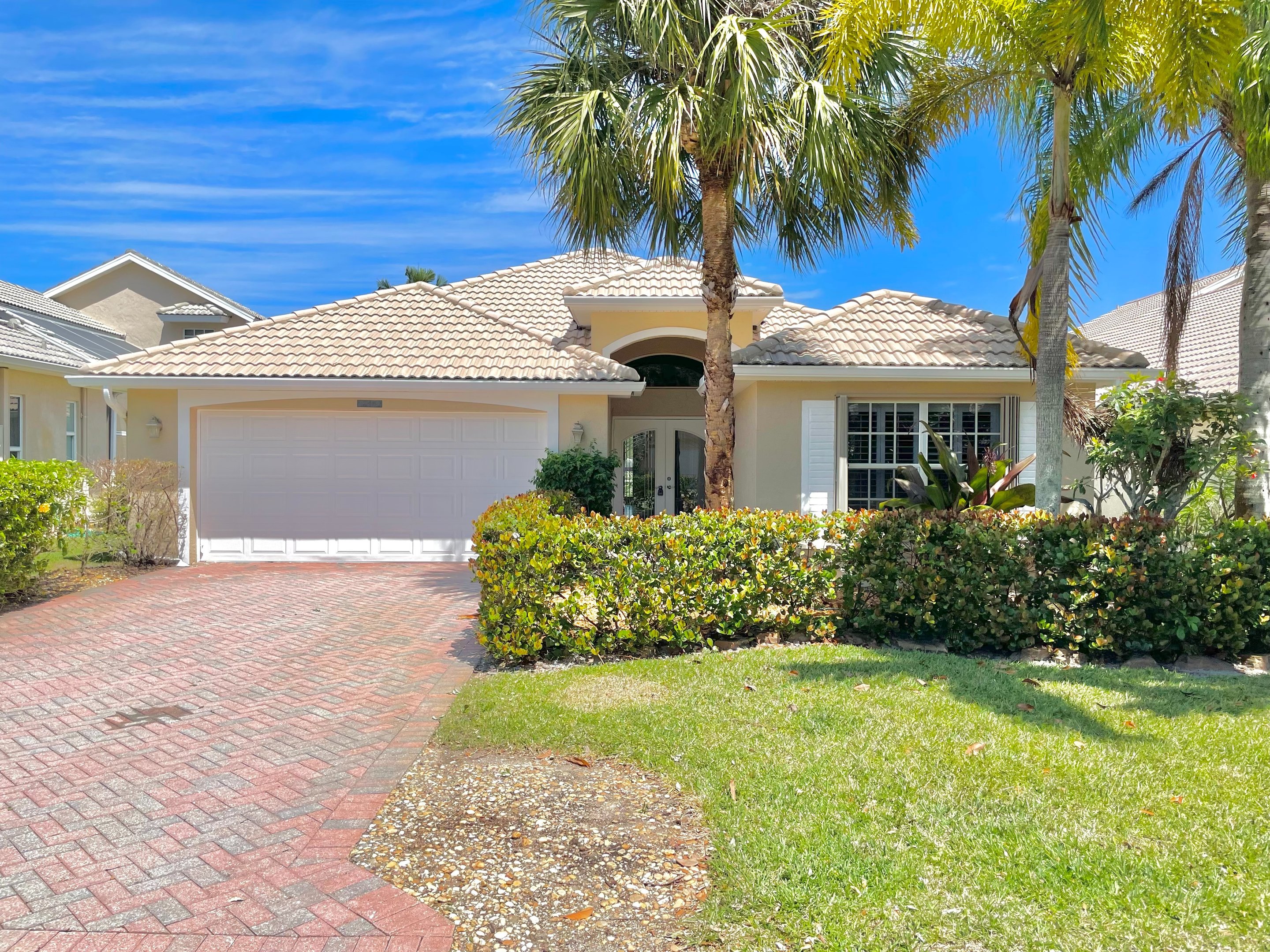 Freshly painted residential home exterior in Stuart, Florida with palm trees