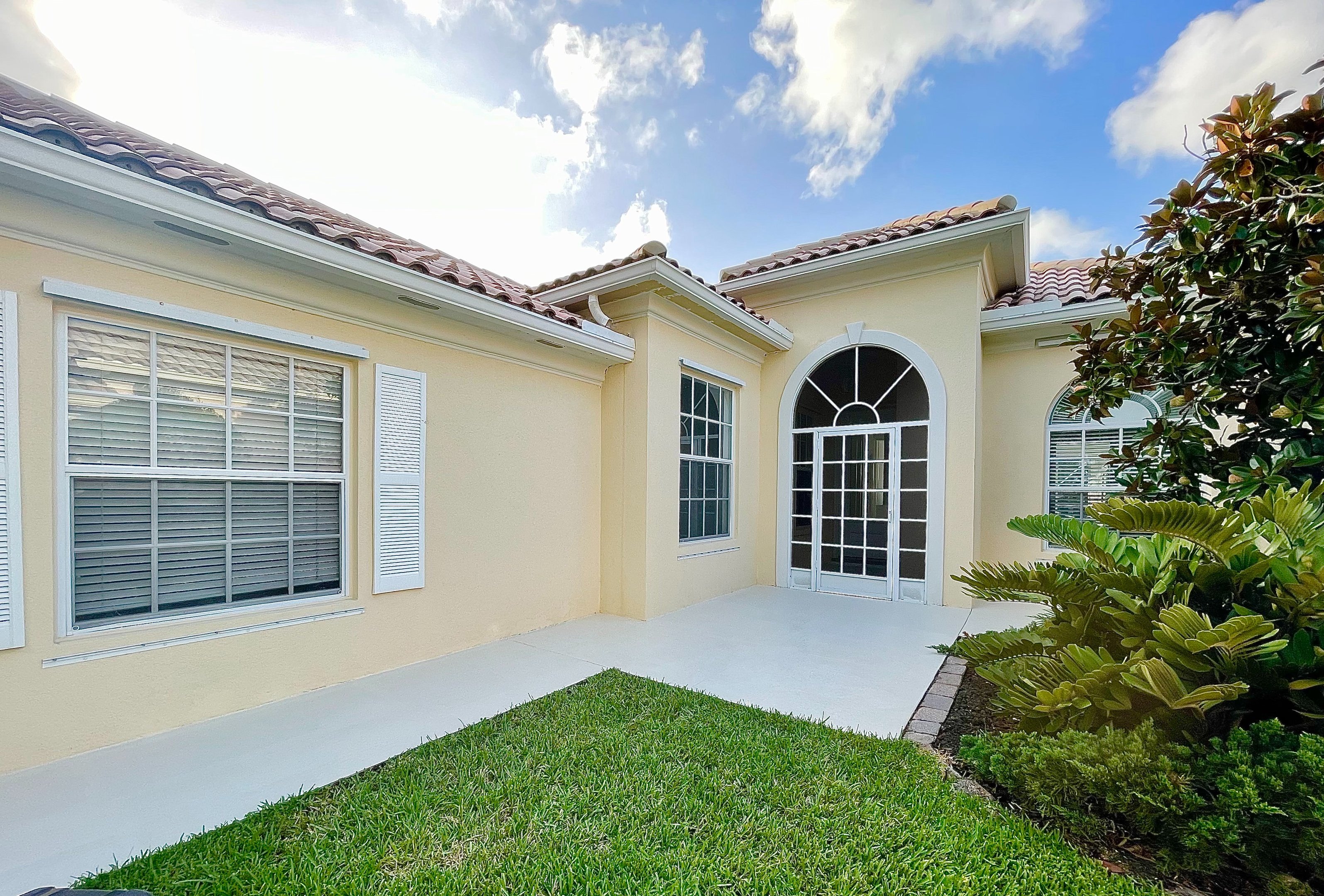 Painted window frames, arched window and front entry on a Stuart FL home