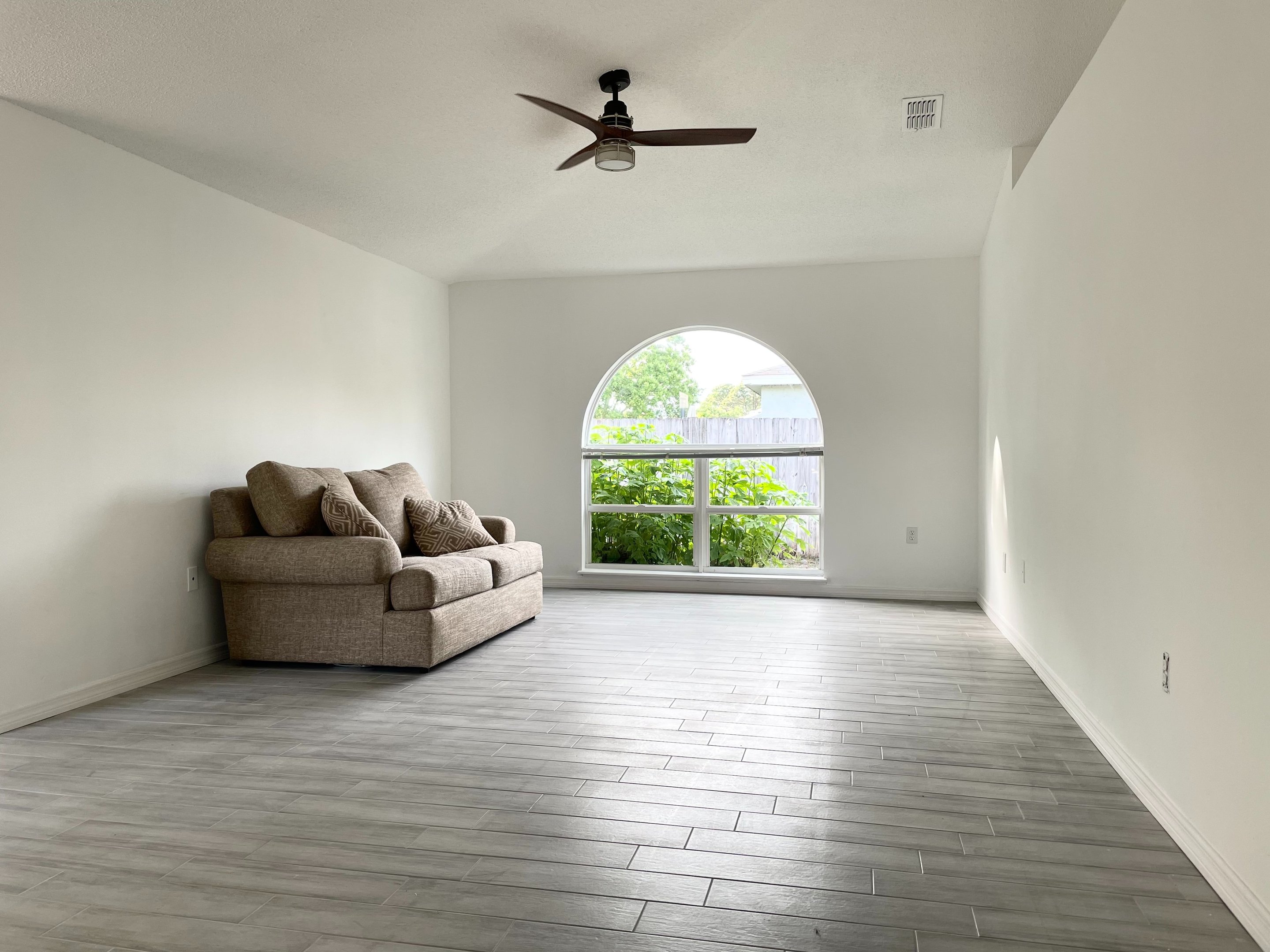 Bright interior living room with arched window, freshly painted in Stuart FL